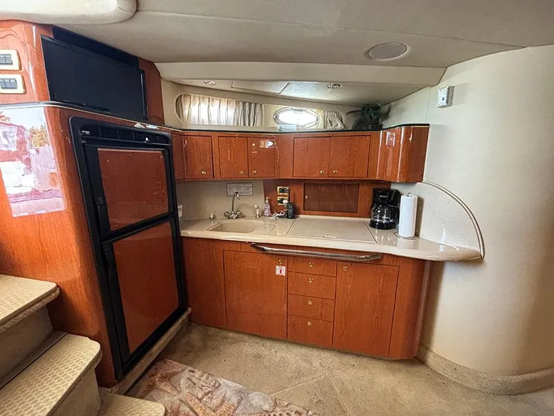 Slide: The Image of 2001 Sea Ray 410 Sundancer yacht interior kitchen with wooden cabinets and modern appliances. - 31