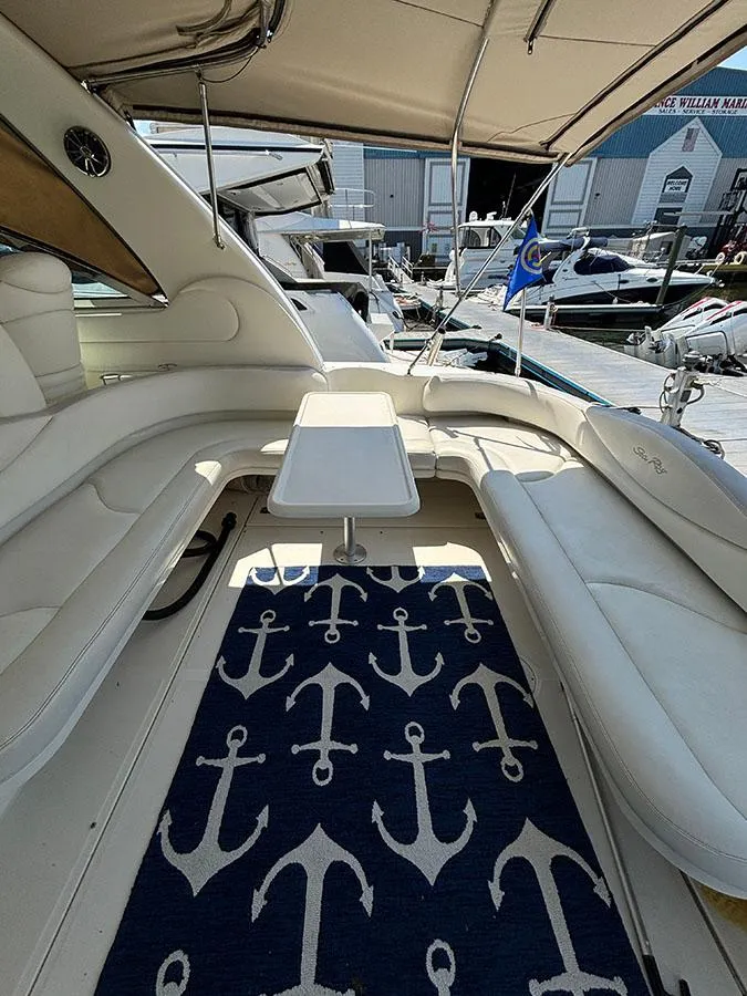 Slide: The Image of 2001 Sea Ray 410 Sundancer boat interior with anchor-themed rug and white seating. - 7