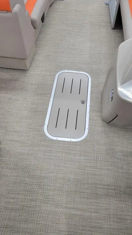 Slide: The Image of 2024 Bennington 20 SL boat interior with carpeted floor and storage hatch. - 5