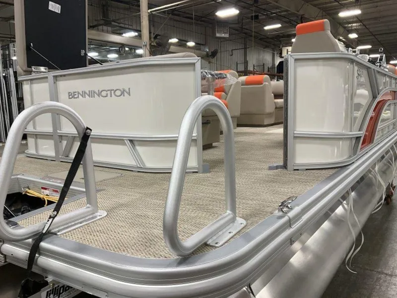 Slide: The Image of 2024 Bennington 20 SL pontoon boat in showroom, featuring white and orange seating. - 9