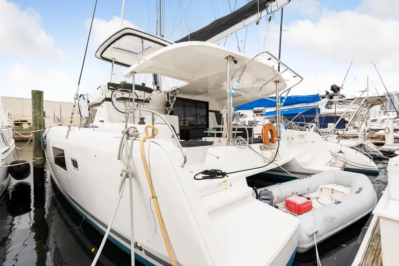 Slide: The Image of 2018 Lagoon 42 catamaran docked with dinghy, white hull, and spacious deck. - 17