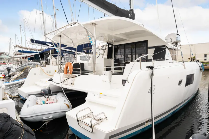 Slide: The Image of 2018 Lagoon 42 catamaran docked at marina with inflatable dinghy. - 19