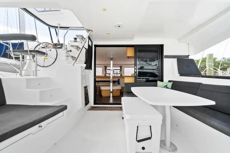 Slide: The Image of Lagoon 42 2018 catamaran cockpit with seating, table, and helm station. - 27