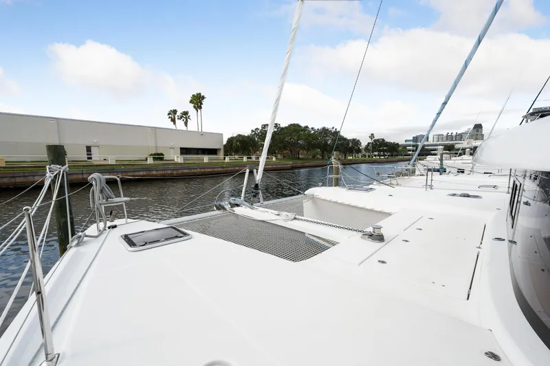 Slide: The Image of 2018 Lagoon 42 catamaran docked by a canal with clear skies. - 38