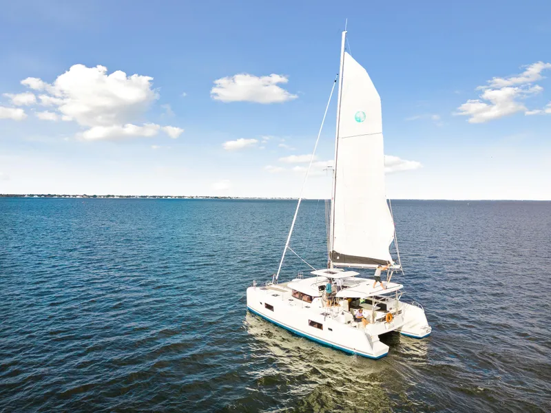 Slide: The Image of 2018 Lagoon 42 catamaran sailing on open water under a clear blue sky. - 9