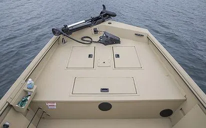 Slide: The Image of 2024 Crestliner 1660 Retriever SC boat deck on water, featuring storage compartments and trolling motor. - 16