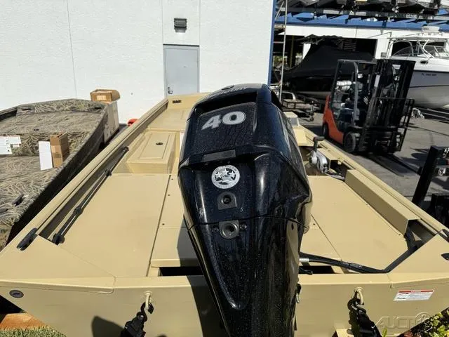 Slide: The Image of 2024 Crestliner 1660 Retriever SC boat with 40 HP outboard motor, docked outdoors. - 5