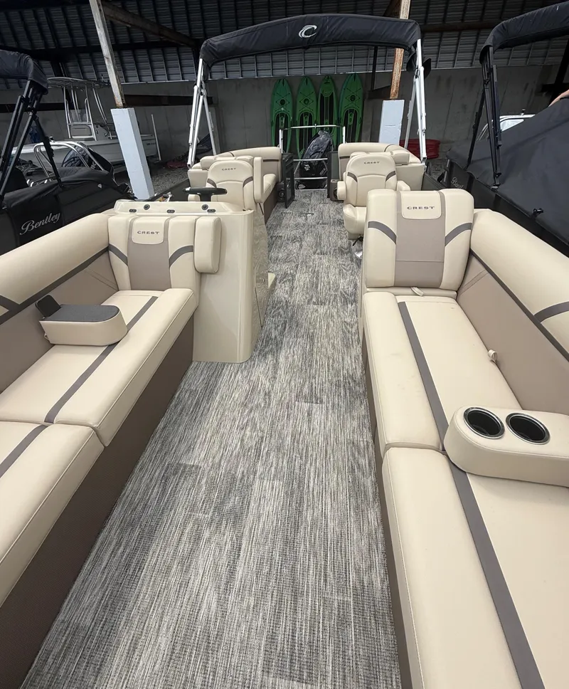 Slide: The Image of 2024 Crest Classic LX 240 pontoon boat interior with beige seating and modern design. - 10