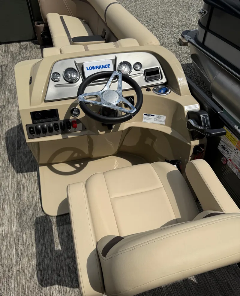 Slide: The Image of 2024 Crest Classic LX 240 boat dashboard with steering wheel and beige seating. - 12
