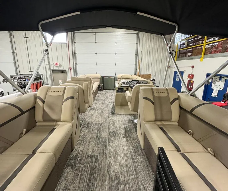 Slide: The Image of 2024 Crest Classic LX 240 pontoon boat interior with beige seating and canopy. - 3
