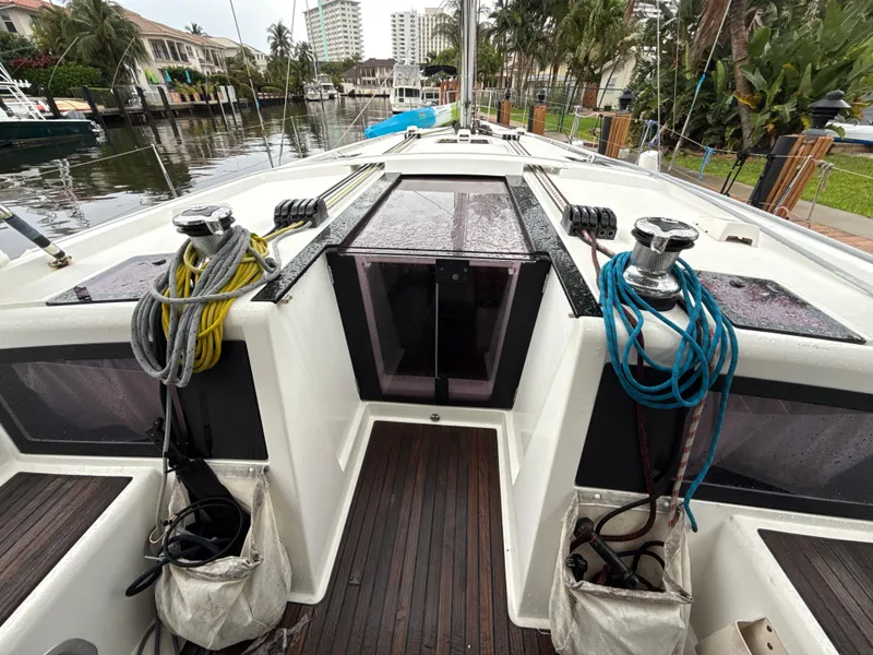 Slide: The Image of Beneteau Oceanis 48 sailboat deck, 2012 model, docked in a scenic marina setting. - 13