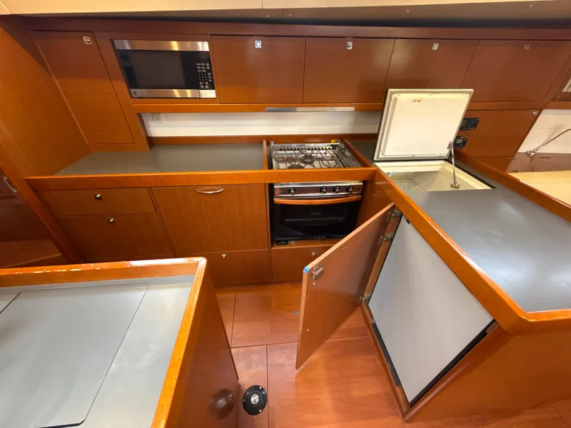 Slide: The Image of Galley kitchen in 2012 Beneteau Oceanis 48 yacht with stove, microwave, and refrigerator. - 18