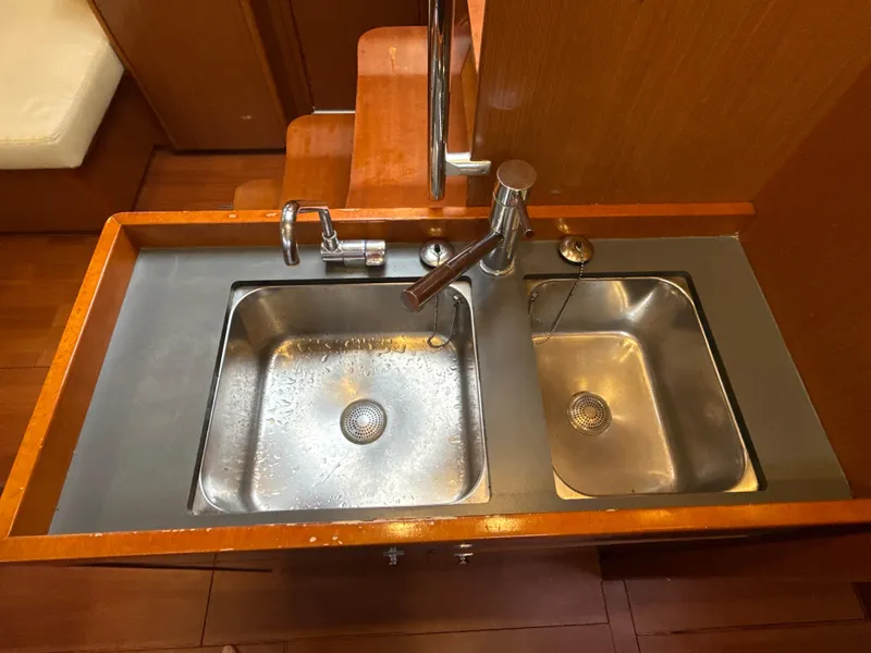 Slide: The Image of Galley sink area in 2012 Beneteau Oceanis 48 yacht, featuring dual stainless steel basins. - 21