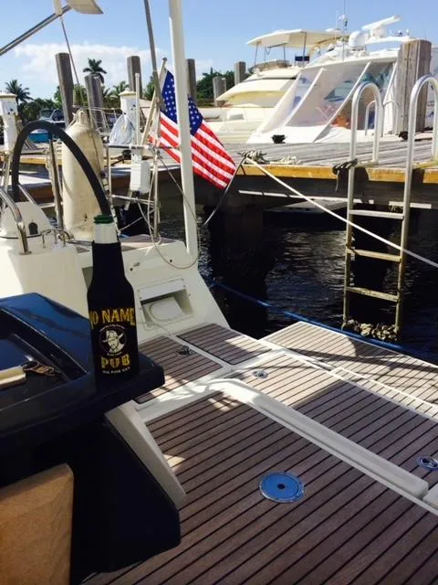 Slide: The Image of Beneteau Oceanis 48 sailboat docked, 2012 model, with American flags and a drink on deck. - 7