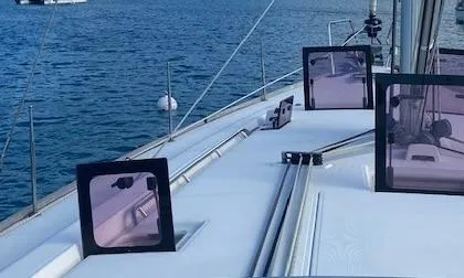 Slide: The Image of Beneteau Oceanis 48 sailboat deck, 2012 model, anchored in calm blue waters. - 8