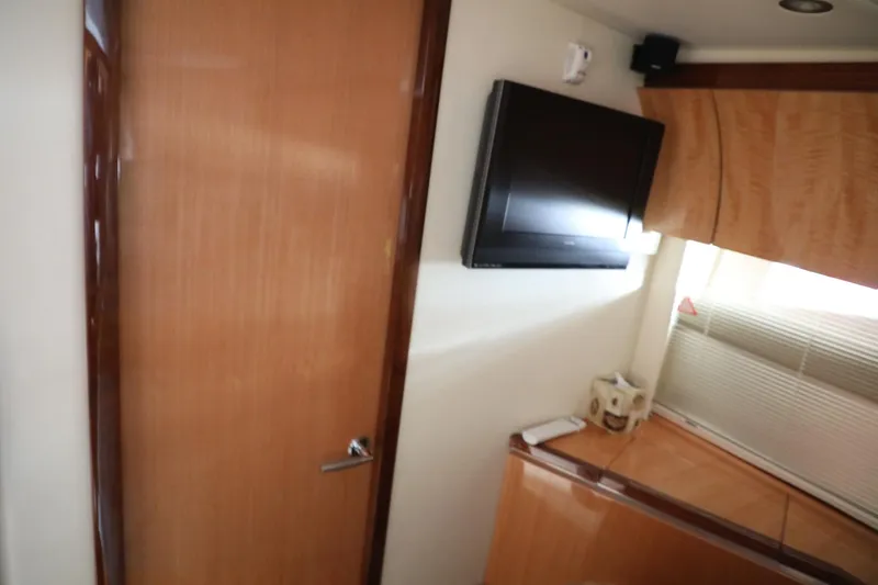 Slide: The Image of Interior of 2008 Cobalt 46 yacht with TV, wooden door, and window blinds. - 26