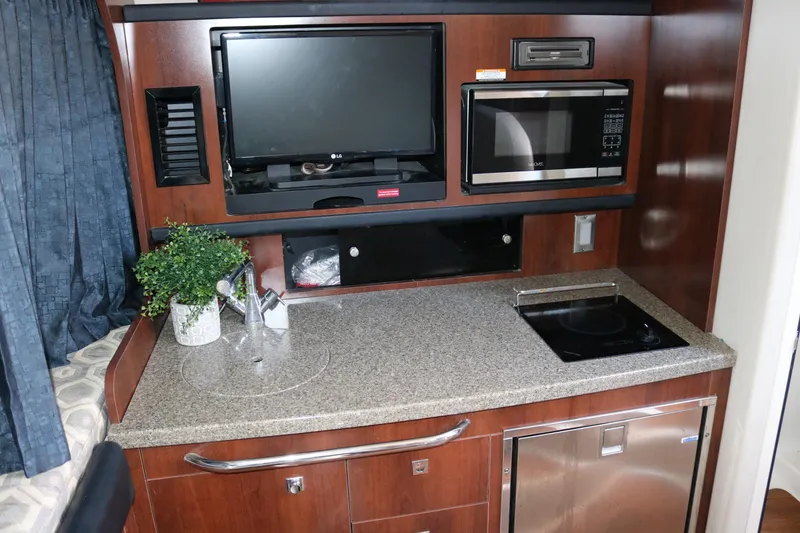 Slide: The Image of Compact kitchen area in 2016 Chaparral 290 Signature boat with TV, microwave, and sink. - 12