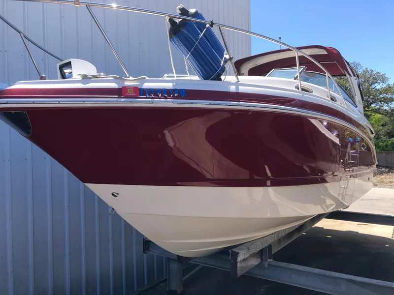 Slide: The Image of 2016 Chaparral 290 Signature boat in red and white, docked at a marina. - 15