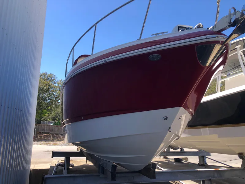 Slide: The Image of 2016 Chaparral 290 Signature boat in dry dock, red and white hull. - 16