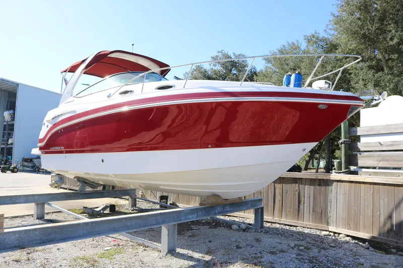 Slide: The Image of 2016 Chaparral 290 Signature boat in red and white on a dry dock. - 2