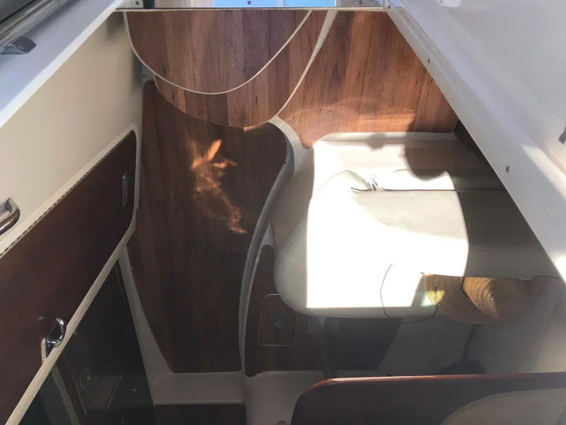 Slide: The Image of Interior view of 2016 Chaparral 290 Signature boat with wood paneling and seating area. - 22