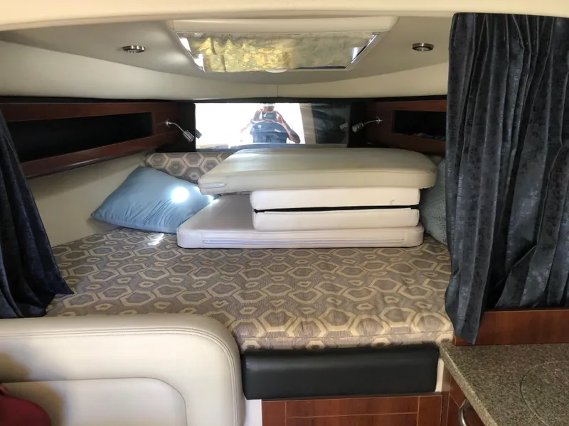 Slide: The Image of 2016 Chaparral 290 Signature cabin interior with bed and cushions. - 23