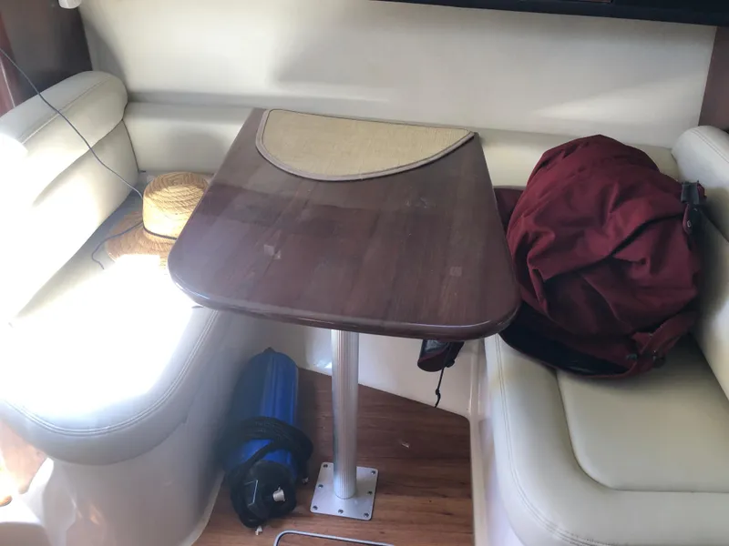 Slide: The Image of Interior of 2016 Chaparral 290 Signature with table, seating, and personal items. - 26