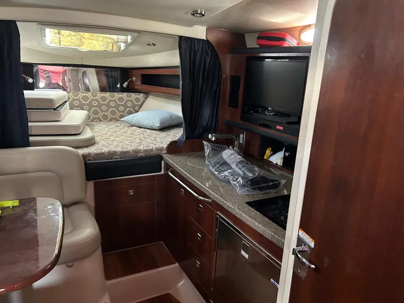 Slide: The Image of Interior of 2016 Chaparral 290 Signature boat with kitchenette and sleeping area. - 33