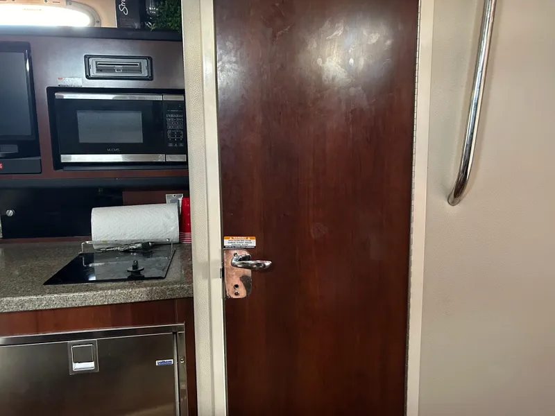 Slide: The Image of Interior of 2016 Chaparral 290 Signature boat with kitchenette and wooden door. - 37