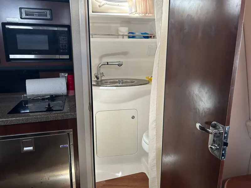 Slide: The Image of Interior of 2016 Chaparral 290 Signature boat showing kitchenette and bathroom. - 38