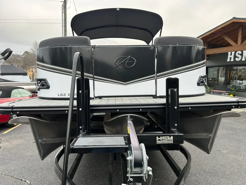 Slide: The Image of 2024 Avalon LSZ 2585 RL pontoon boat on trailer, rear view. - 2