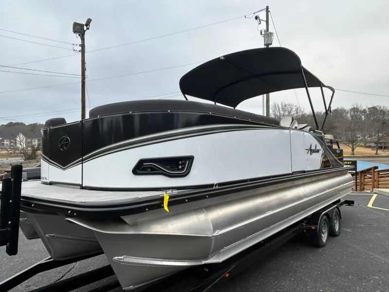 Slide: The Image of 2024 Avalon LSZ 2585 RL pontoon boat on a trailer, side view. - 3