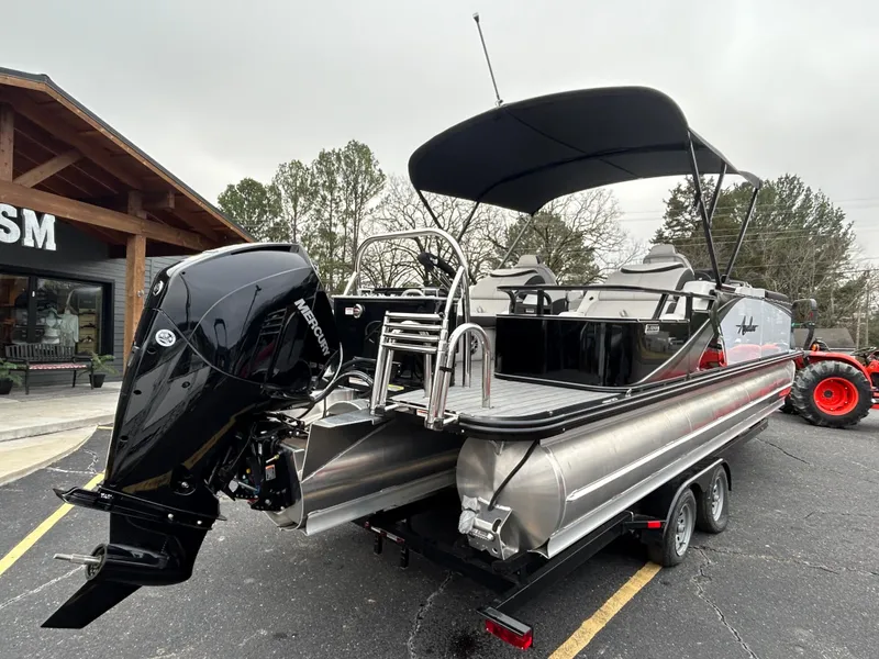 Slide: The Image of 2024 Avalon LSZ 2585 RL pontoon boat with black canopy and powerful outboard motor. - 7