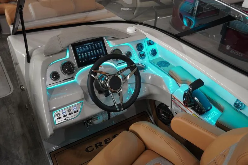 Slide: The Image of 2024 Crest Continental 250 SLC CP3 boat dashboard with illuminated controls and modern steering wheel. - 5