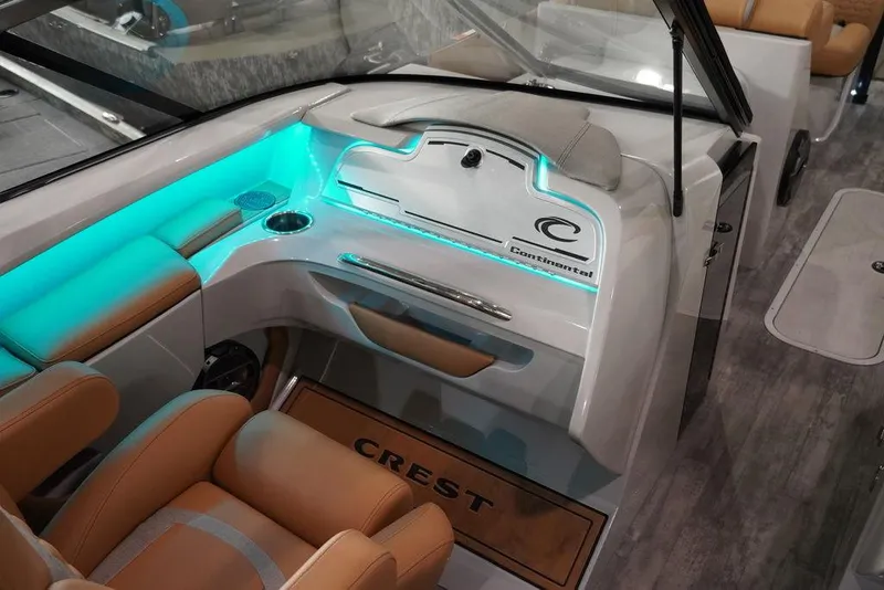 Slide: The Image of 2024 Crest Continental 250 SLC CP3 boat interior with illuminated dashboard and tan seating. - 8