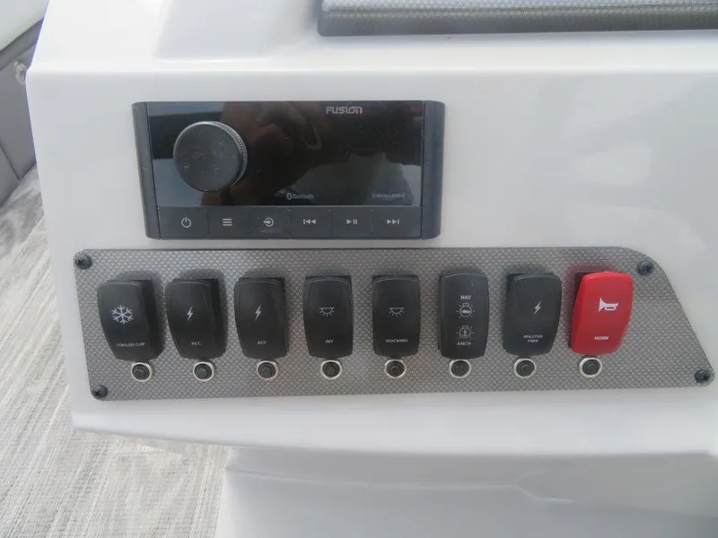 Slide: The Image of Control panel of 2024 Crest CLASSIC LX 240 SLC boat with switches and Fusion stereo. - 6