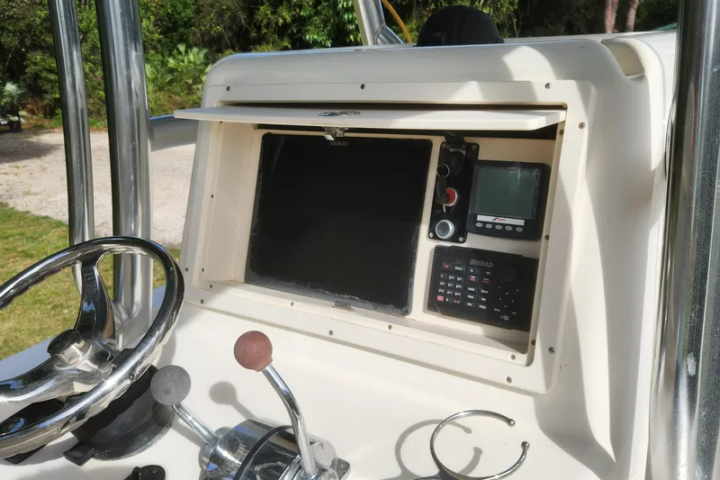Slide: The Image of 2013 Panga Center Console boat dashboard with steering wheel and navigation equipment. - 11