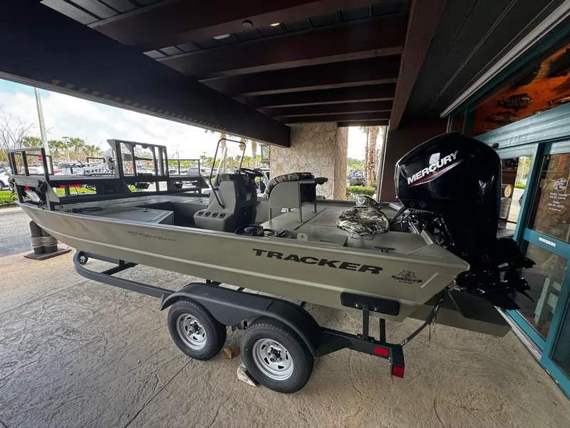 Slide: The Image of 2024 Tracker Grizzly 2072 CC Sportsman boat on a trailer with Mercury outboard motor. - 2