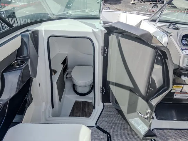 Slide: The Image of 2024 Monterey 258 SS boat interior with open door revealing compact bathroom. - 27