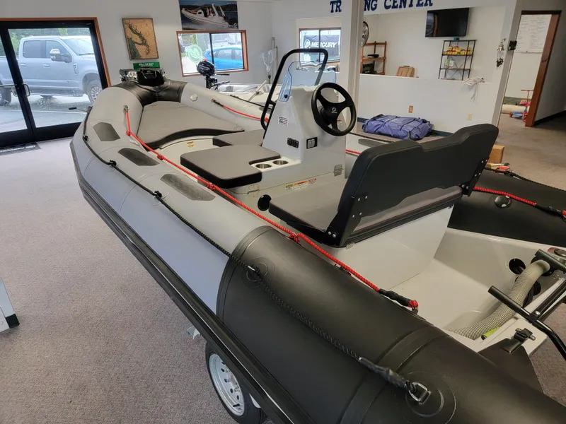 Slide: The Image of 2024 Zodiac Open 4.8 inflatable boat displayed indoors, featuring sleek design and modern controls. - 5