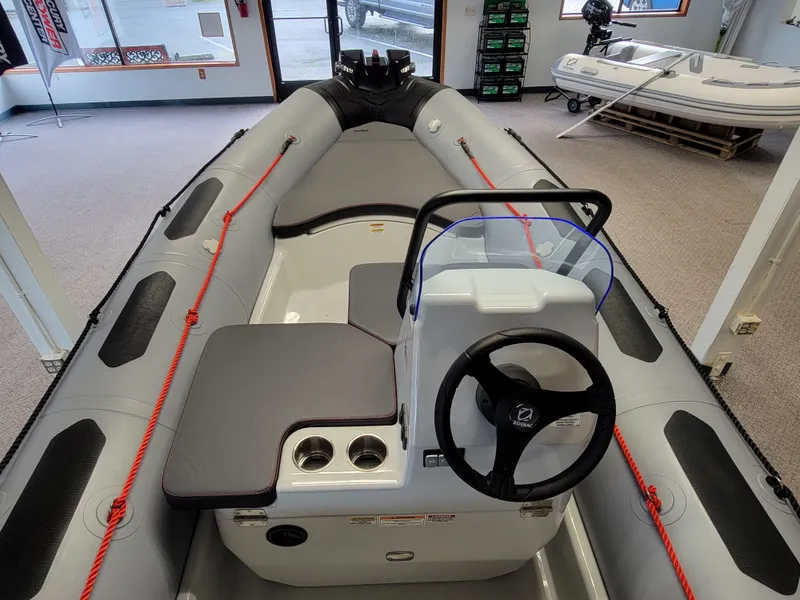 Slide: The Image of 2024 Zodiac Open 4.8 inflatable boat interior with steering console and seating. - 7