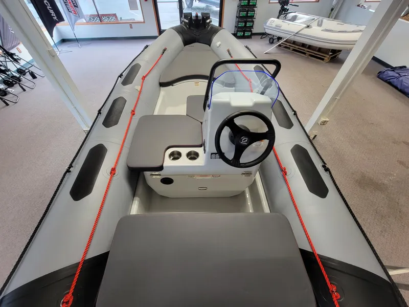 Slide: The Image of 2024 Zodiac Open 4.8 inflatable boat interior with steering console and seating. - 8