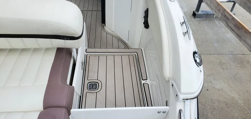 Slide: The Image of 2013 Cobalt 24SD boat interior with white and beige seating and wood-style flooring. - 18