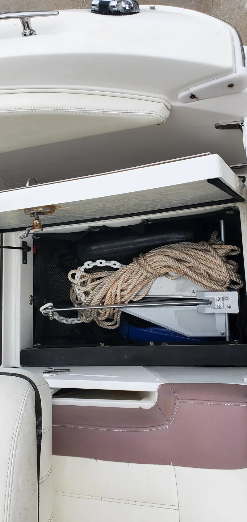 Slide: The Image of Storage compartment in a 2013 Cobalt 24SD boat with rope and anchor. - 20