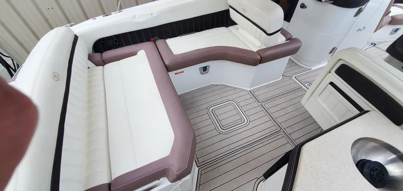 Slide: The Image of 2013 Cobalt 24SD boat interior with white and brown seating, sleek design, and modern flooring. - 23