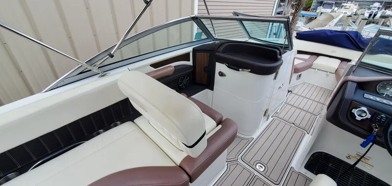 Slide: The Image of 2013 Cobalt 24SD boat interior with white and brown seating, modern dashboard, and spacious layout. - 25
