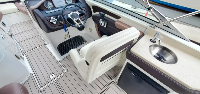Slide: The Image of 2013 Cobalt 24SD boat interior with steering wheel, dashboard, and sink. - 28