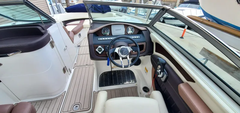 Slide: The Image of 2013 Cobalt 24SD boat interior with steering wheel, dashboard, and seating. - 29