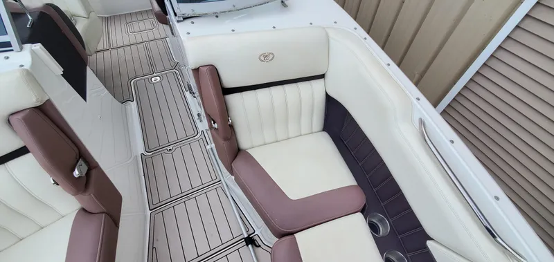 Slide: The Image of 2013 Cobalt 24SD boat interior with white and brown seating, sleek design, and cup holders. - 43