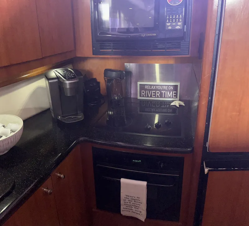 Slide: The Image of Kitchen area of 2002 Carver 466 Motor Yacht with appliances and "River Time" sign. - 21
